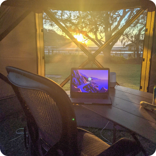 A laptop and office chair in a tent